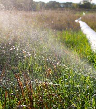 Water spraying from a leak in a long outdoor pipeline, symbolising hidden inefficiencies in fund administration.